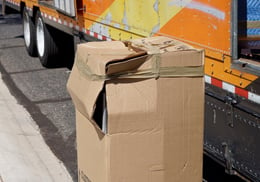 damaged-box-unloaded-from-a-moving-van-cargo-area-56EU78C