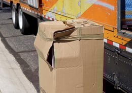 damaged-box-unloaded-from-a-moving-van-cargo-area-56EU78C